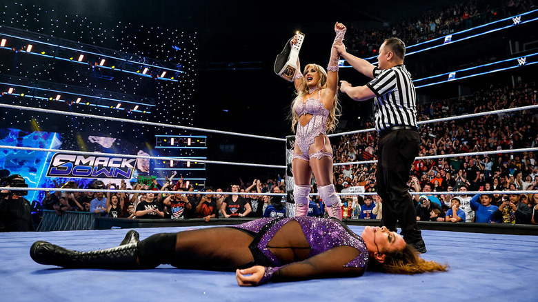 Tiffany Stratton raises her title belt over a fallen Nia Jax in the ring on "WWE SmackDown."