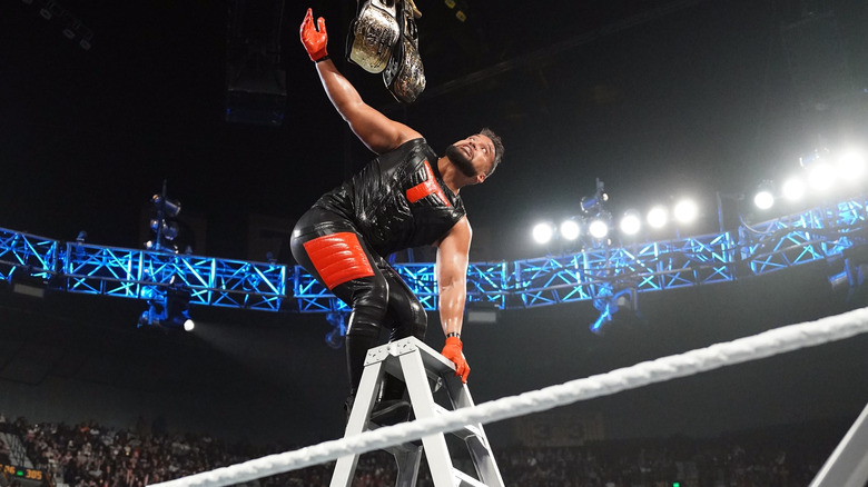 Tanga Loa on top of ladder with title belts