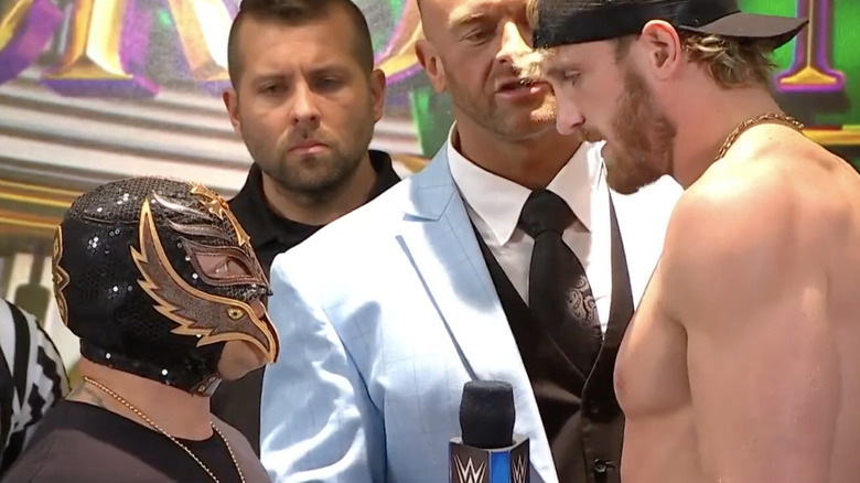 Rey Mysterio stares up at Logan Paul