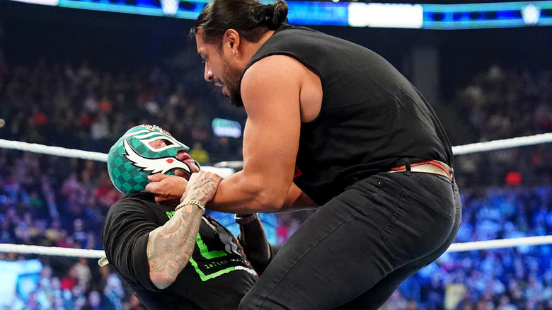 Santos Escobar grabbing Rey Mysterio's face