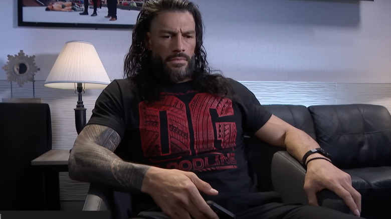 Roman Reigns sits dejected with his phone in hand backstage on "WWE SmackDown."