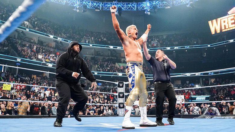 Cody Rhodes raises his arms while the referee tries to warn him that Solo Sikoa is behind him on "WWE SmackDown"