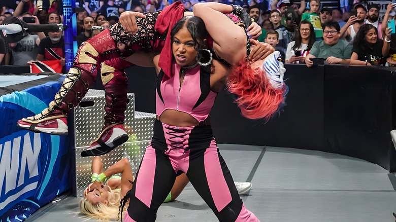 Bianca Belair with Asuka on her shoulders