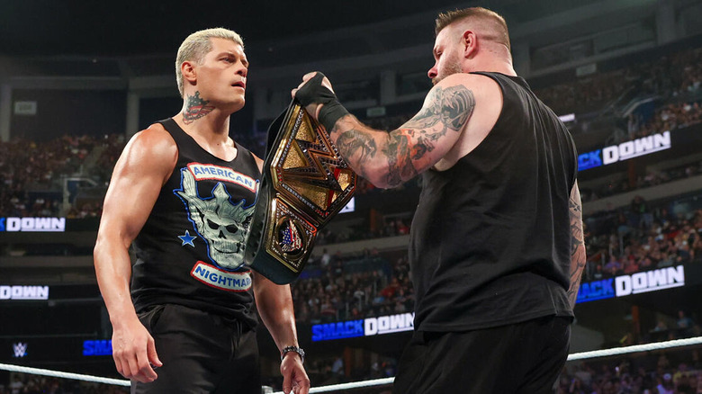 Kevin Owens hands Cody Rhodes the title belt