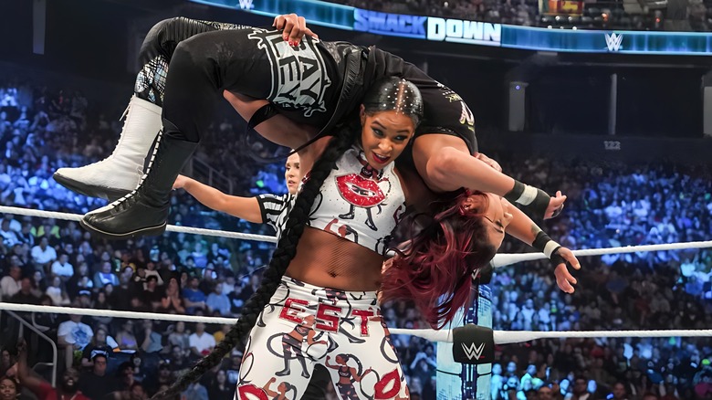 Bianca Belair with Bayley on her shoulders