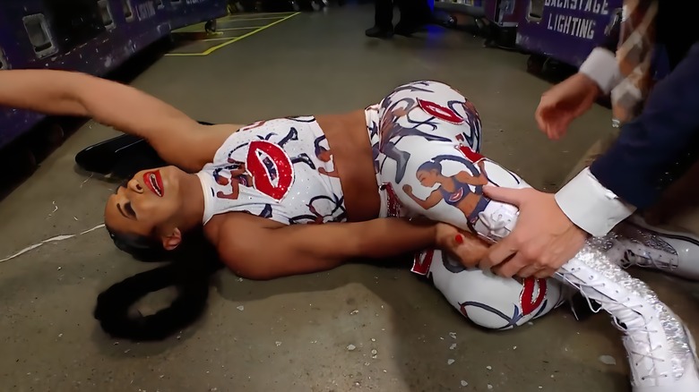 Bianca Belair writhing on the ground in pain