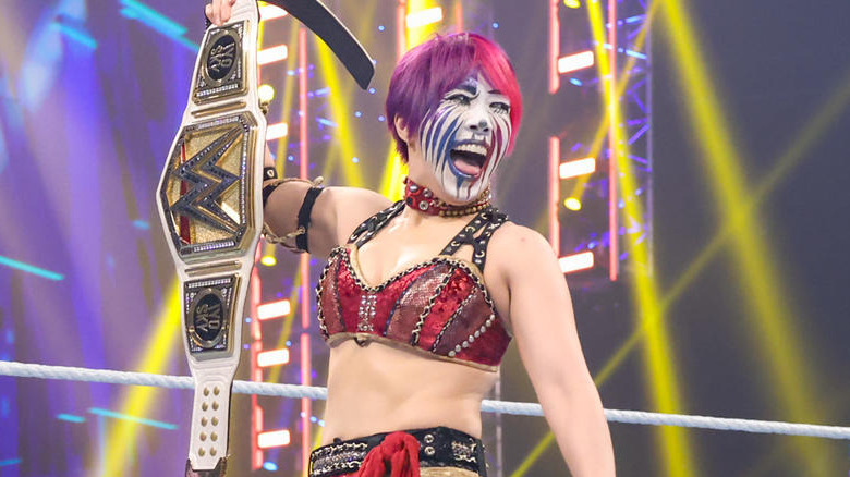 Asuka holding up women's title belt