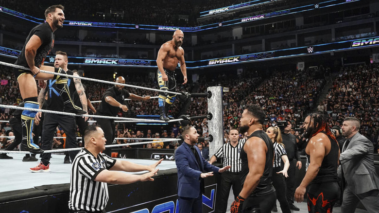 Johnny Gargano and Tommaso Ciampa of #DIY accompany Kevin Owens in the ring. WWE officials separate them from Tonga Loa and Jacob Fatu on the outside.