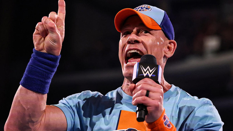 John Cena with a finger held up and a mcrophone