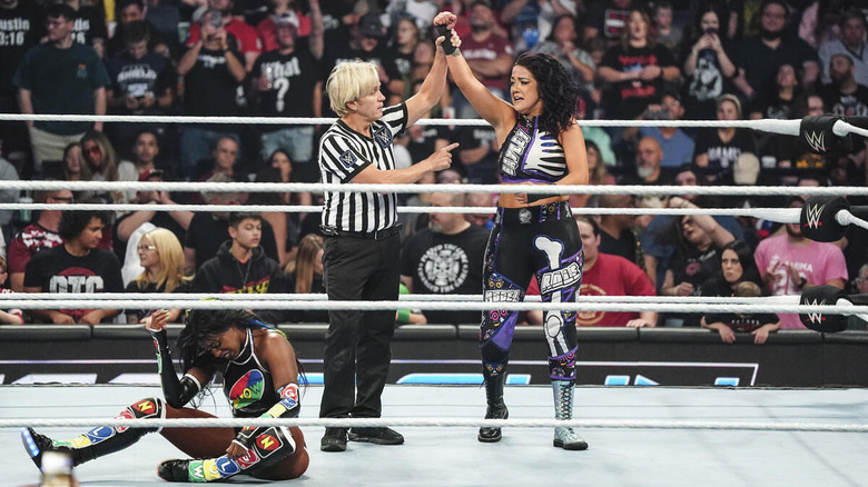 Bayley gets her hand raised while Naomi sits in the ring