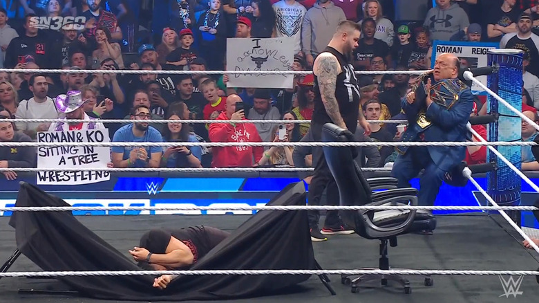 Owens staring down Heyman as Reigns is laid out