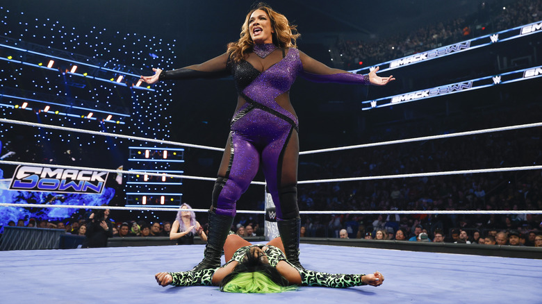 Nia Jax posing while standing over a prone Naomi on "WWE SmackDown."