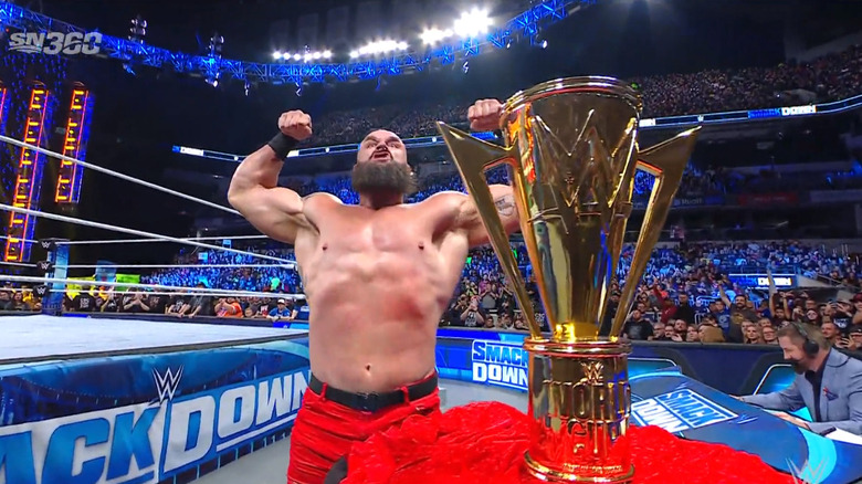 Strowman posing next to the trophy