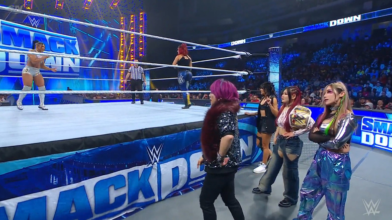 Belair and Bayley in the ring as the rest of Damage CTRL watches on from the outside