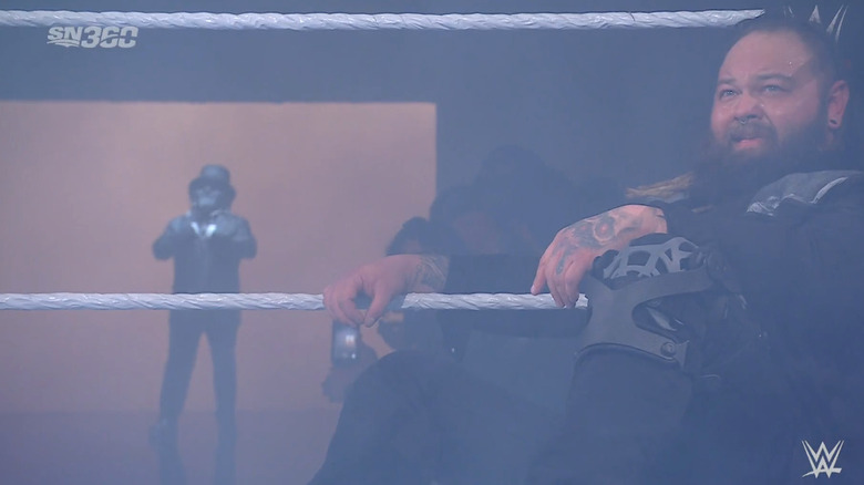 Wyatt in the ring as Uncle Howdy stands on the ramp