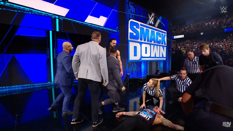 McIntyre standing over Punk on the ramp as officials check on him