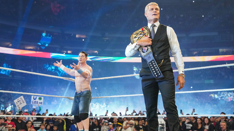 Rhodes in the ring with his Undisputed WWE Championship as Cena stands behind him