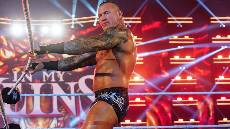 Randy Orton looks to his left while holding the ropes
