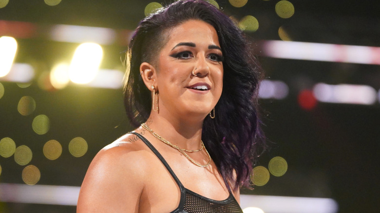 Bayley is wearing gold dangly earrings.