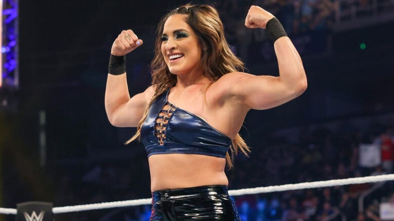 Raquel Rodriguez flexes and poses in the middle of the ring before a match on WWE TV.