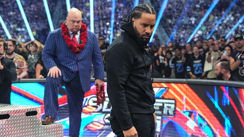 Jimmy Uso looking downward with Paul Heyman behind him