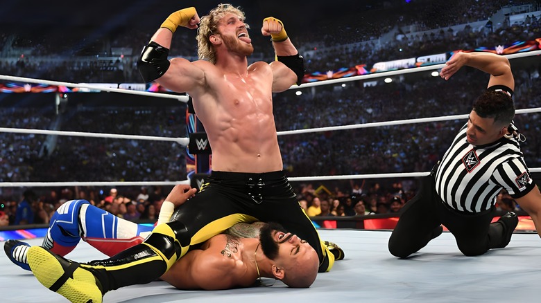 Logan Paul straddling Ricochet