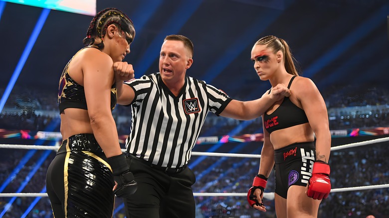 Referee holds Shayna Baszler and Ronda Rousey apart