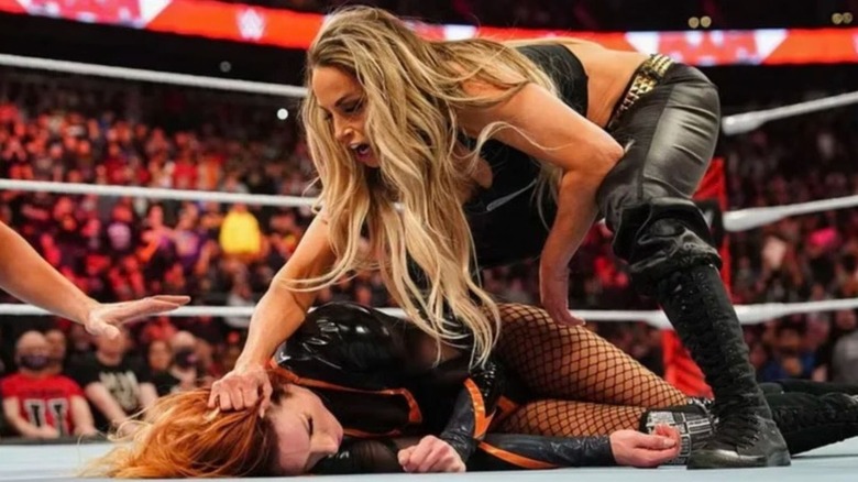 Trish Stratus stands over a fallen Becky Lynch