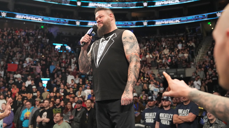 Kevin Owens with microphone stands in the crowd on "WWE SmackDown."