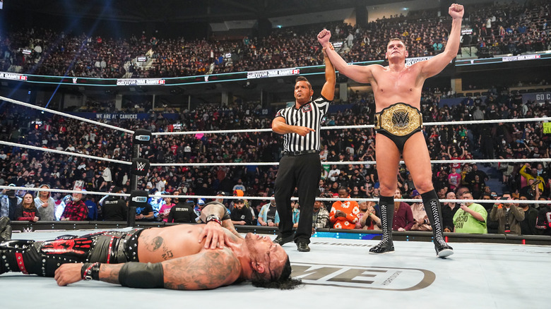 Referee raises GUNTHER's arm as he stands in the ring above a fallen Damian Priest at WWE Survivor Series.