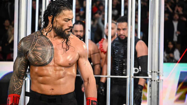 Roman Reigns looks back at the heel team in the shark cage at WWE Survivor Series.