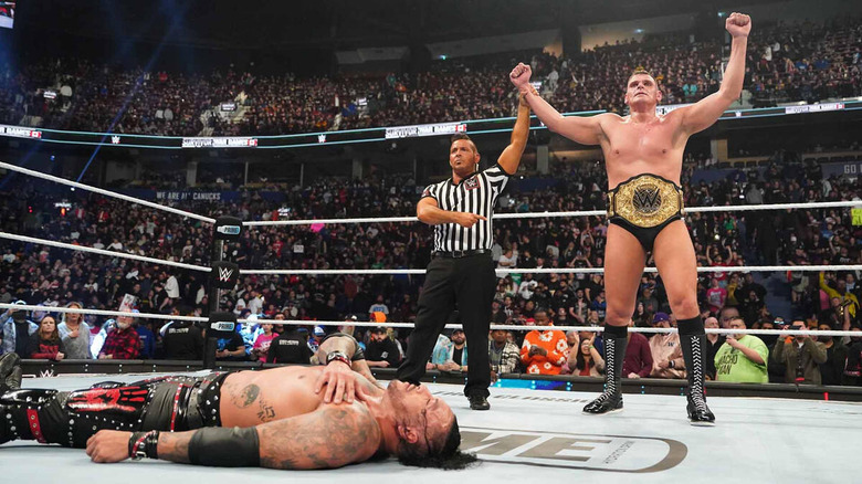 Referee raises GUNTHER's arms as Damian Priest lies fallen in the foreground at WWE Survivor Series