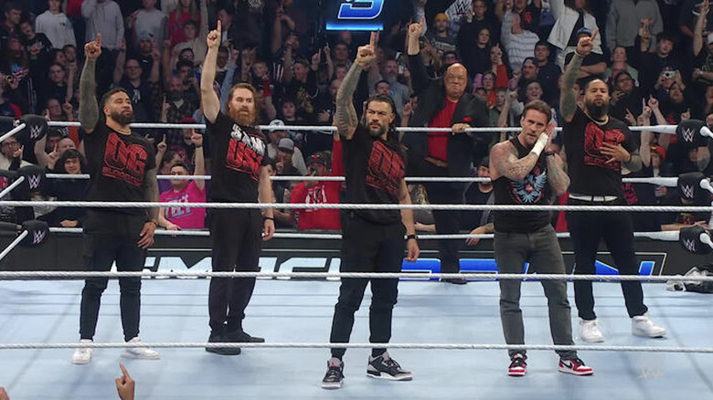 Reigns, Zayn, The Usos, and Punk standing ta in the ring