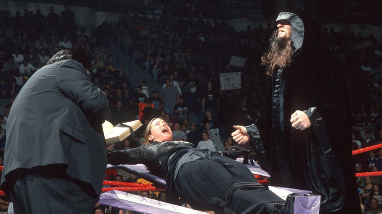 Stephanie McMahon strapped to Undertaker's symbol