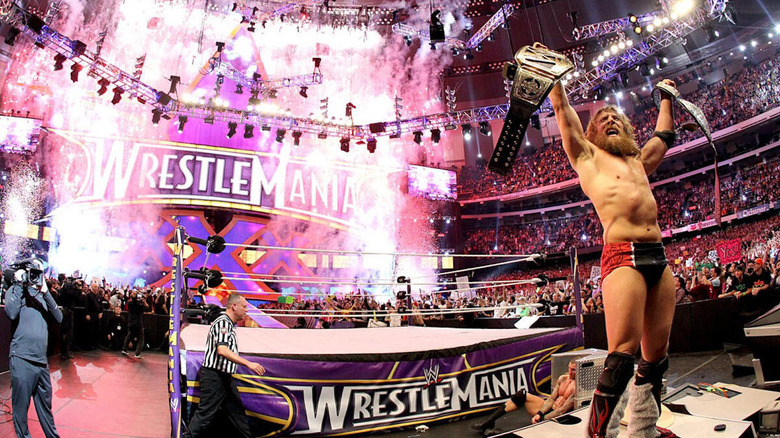 Daniel Bryan raises world title belts while fireworks go off behind him