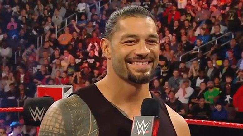 Roman Reigns smiling after making an announcement