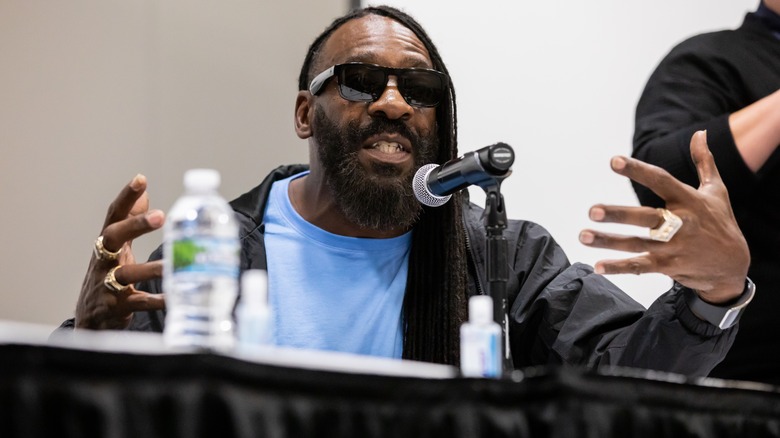 Booker T talking into a microphone at an event