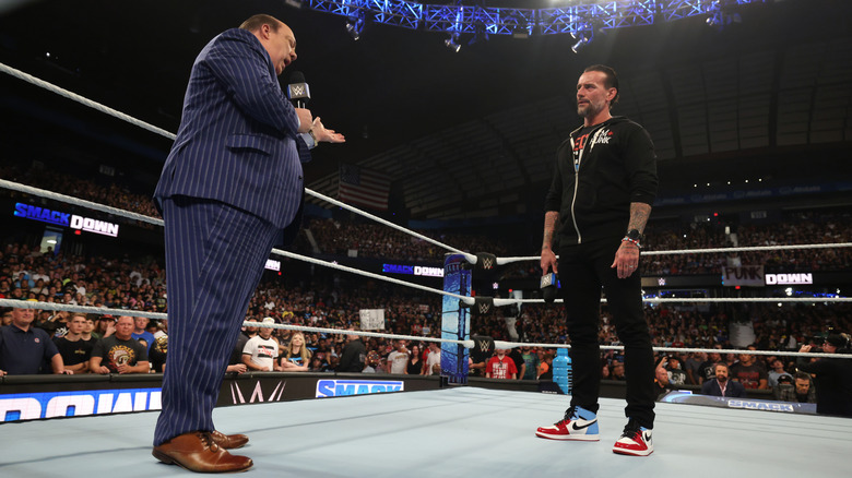 CM Punk listens to Paul Heyman during an in-ring confrontation on WWE SmackDown