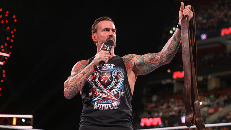 CM Punk speaks while holding a leather strap