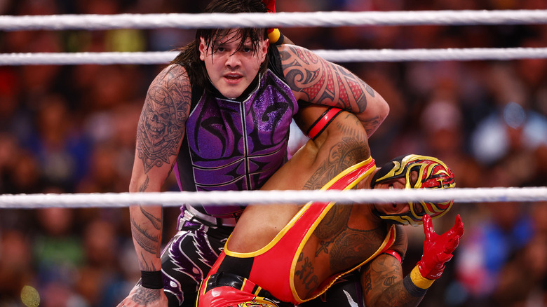 Dominik Mysterio applying submission hold to Rey Mysterio