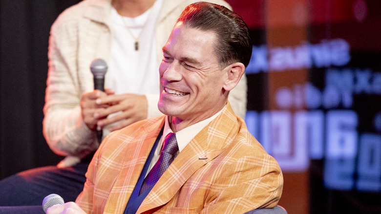 John Cena laughing in an orange jacket