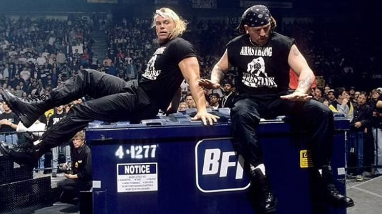 The New Age Outlaws sitting on a dumpster