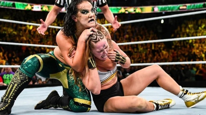 Shayna Baszler puts Ronda Rousey in a headlock in the ring