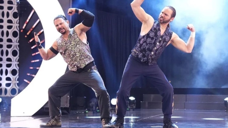 The Young Bucks, Matthew and Nicholas Jackson, flex and pose on the stage before a match on AEW television.